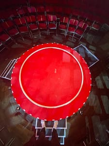 Oscar Kaufmann als The Flying Gentleman auf der ikonischen roten Bühne von La Clique – ein Cyr Wheel Act voller Eleganz und Nostalgie auf winziger Bühne