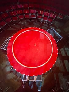 Oscar Kaufmann als The Flying Gentleman auf der ikonischen roten Bühne von La Clique – ein Cyr Wheel Act voller Eleganz und Nostalgie auf winziger Bühne